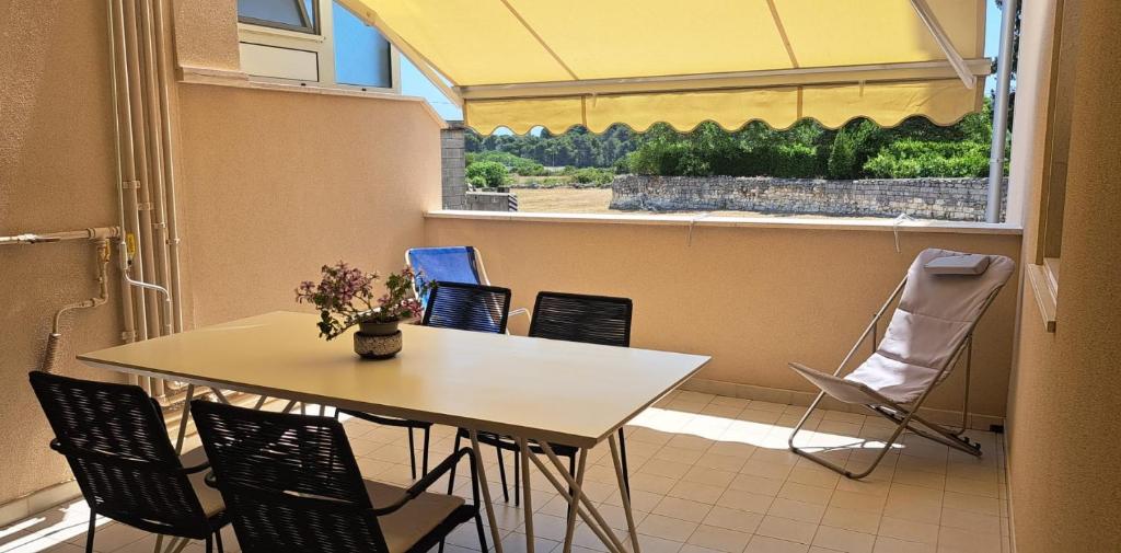a table and chairs in a room with a window at Nonna Eleonora in Otranto