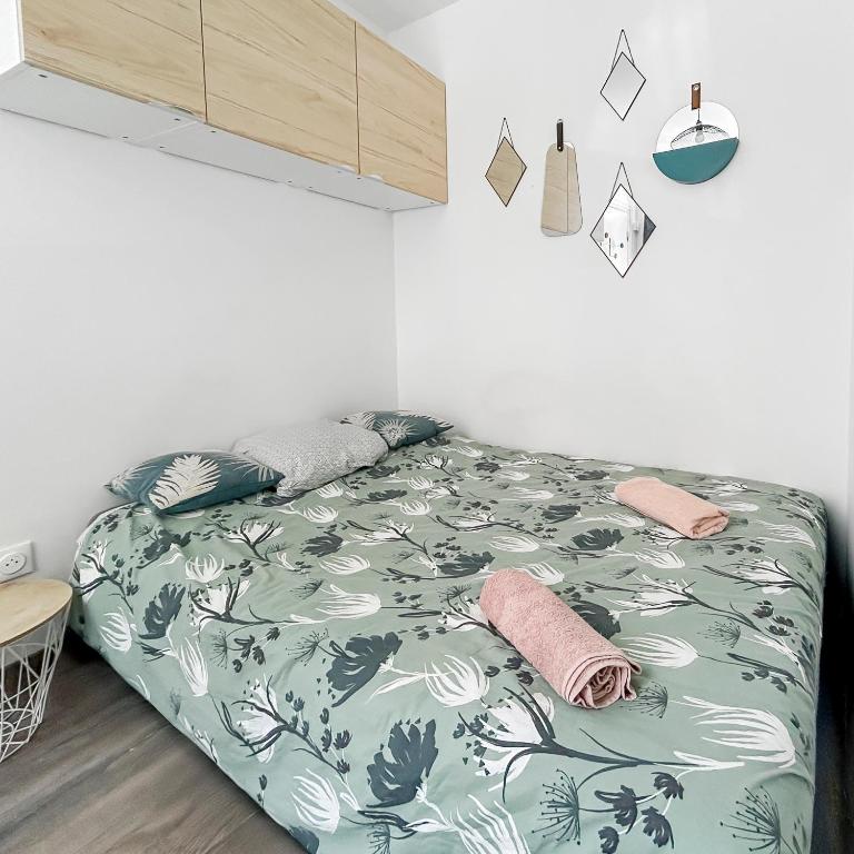 - une chambre avec un lit et une couette verte et blanche dans l'établissement Studio à Montluçon, à Montluçon