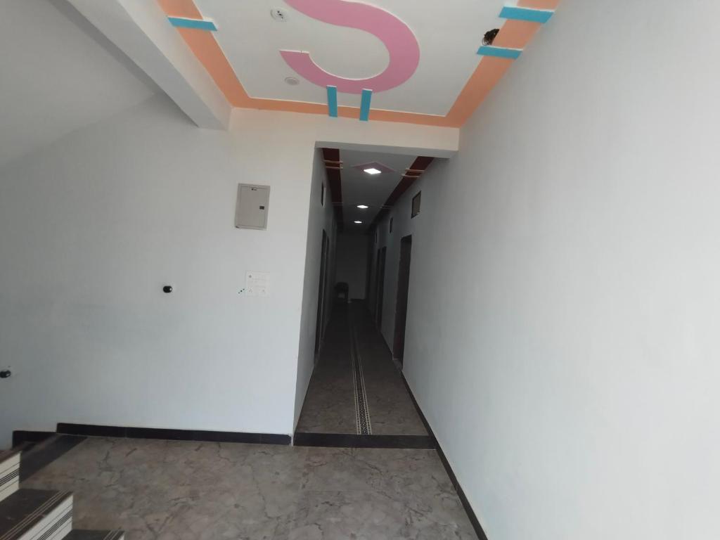 a hallway in a building with a ceiling with a letter on it at Singh shab hotel in Orchha