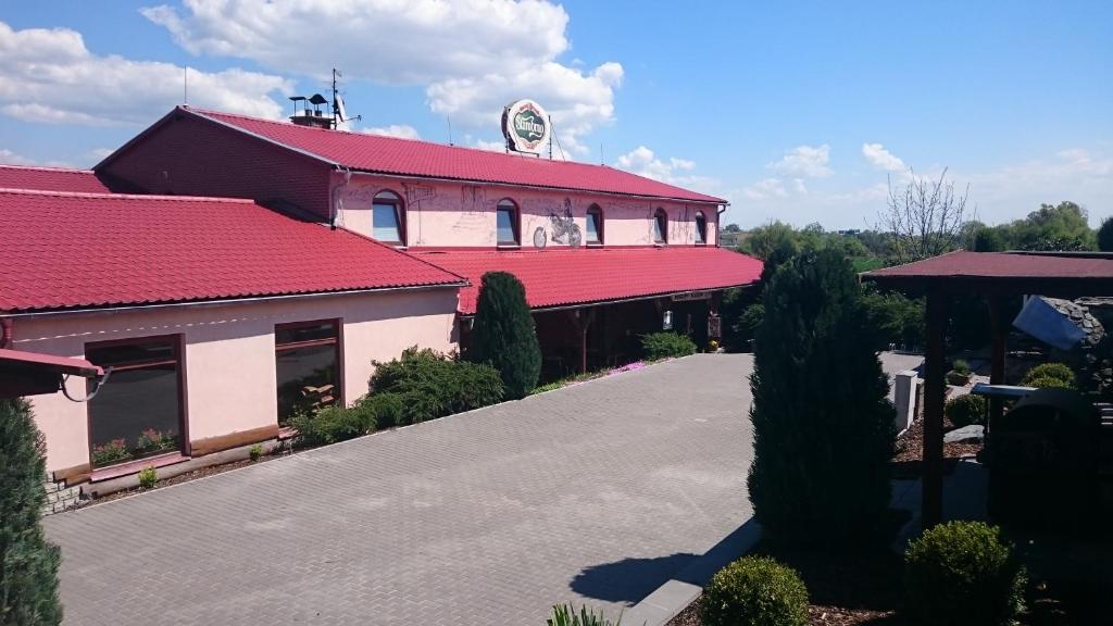 um edifício com um telhado vermelho e uma entrada em Penzion Jaroš em Popůvky