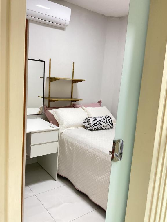 a small bedroom with a bed and a mirror at Cacau estadia in Canindé de São Francisco
