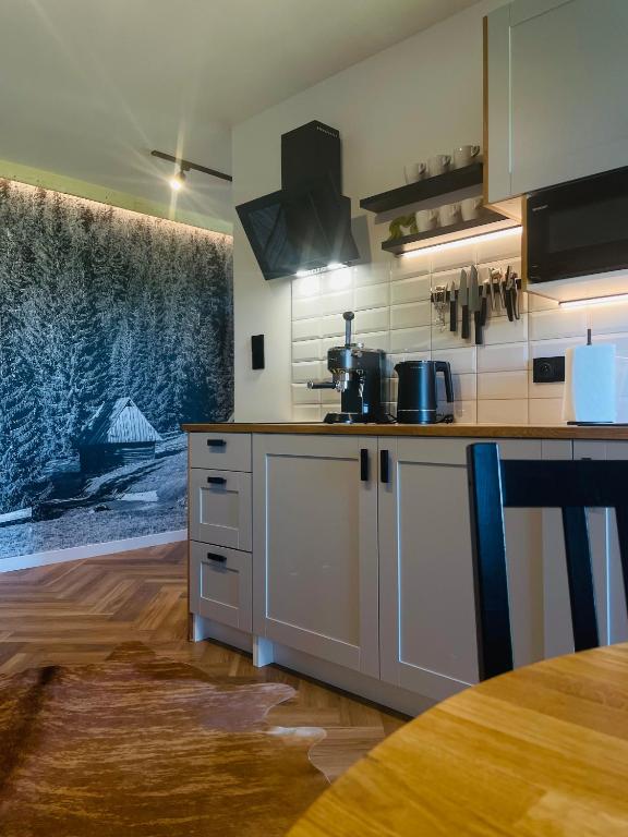 a kitchen with white cabinets and a counter top at Apartament u Jagi Sądelska 119f in Murzasichle