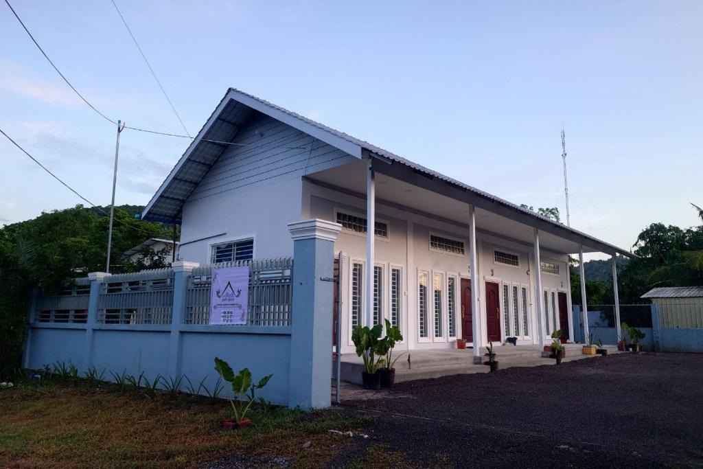 a white building with a blue at Phnom Sampov Homestay ផ្ទះលំហែភ្នំសំពៅ in Phumĭ Kdaông Khang Tbong