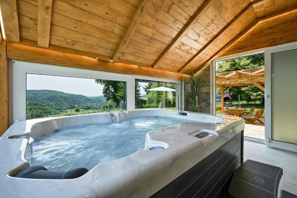 bañera grande en una habitación con ventana grande en Private Villa with Pool and Jacuzzi Dreamy Hill, en Pregrada