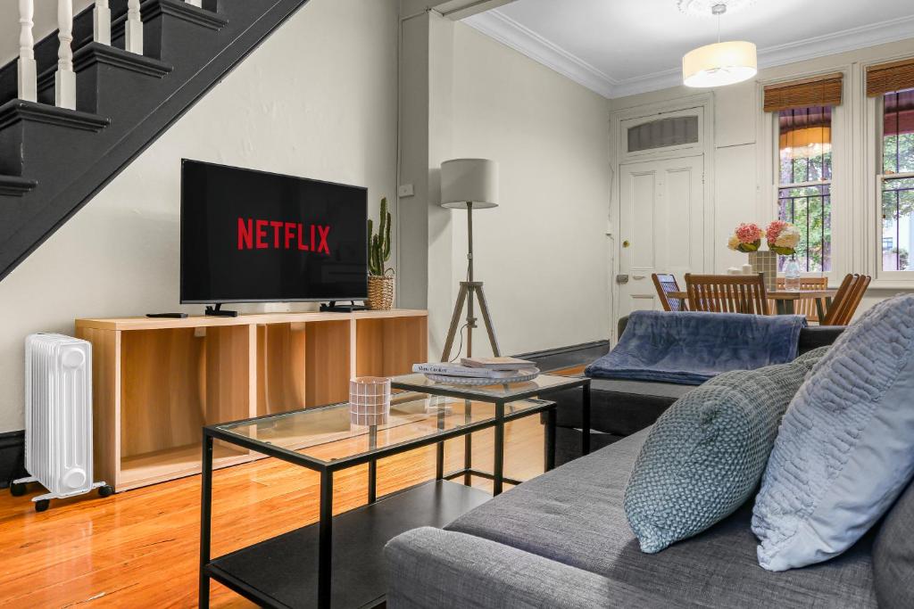 a living room with a couch and a tv at 2 Bedroom House Surry Hills Good for 6 Guests in Sydney