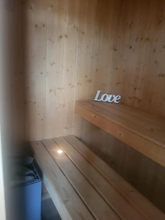 a wooden bench in a sauna with the words love at Le conviviale in Belfort