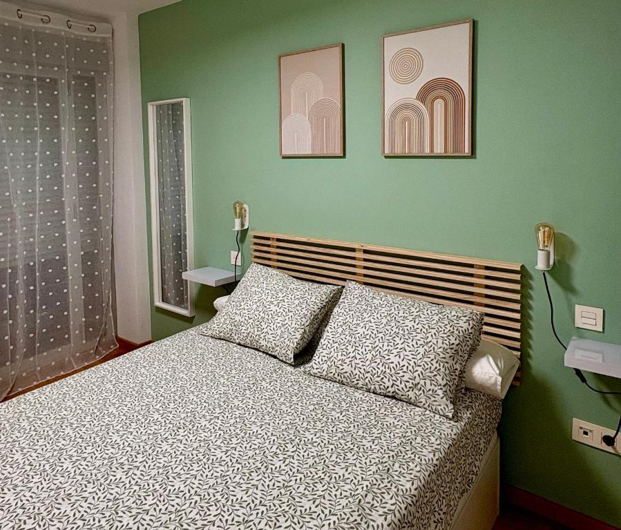 ein Schlafzimmer mit einem Bett und zwei Bildern an der Wand in der Unterkunft Apartamento Blesino in Saragossa