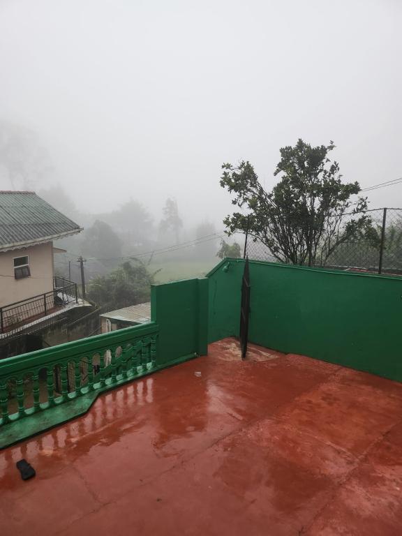 a green fence on the side of a house at Bella Casa villa in Nuwara Eliya