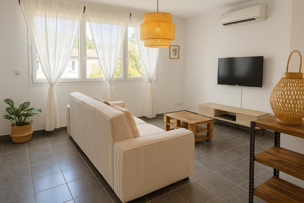 un salon avec un canapé blanc et une télévision dans l'établissement APPARTEMENT T3 65 m2 CENTRE VILLE, à Porto-Vecchio
