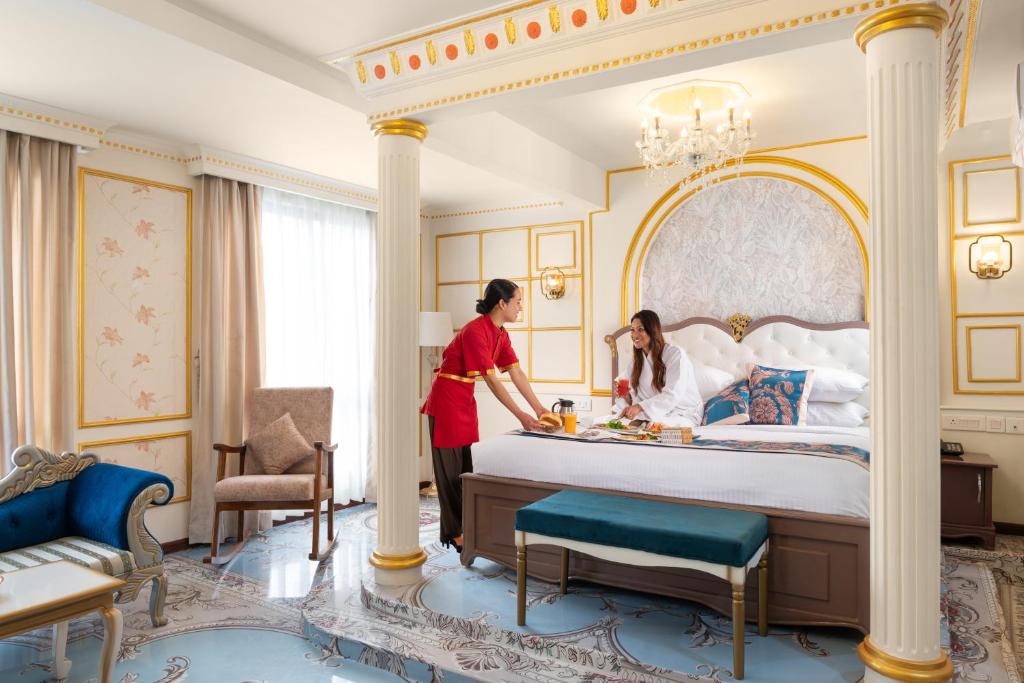 two women making a bed in a hotel room at Hotel G Ramayana- Premium Stay in Kathmandu
