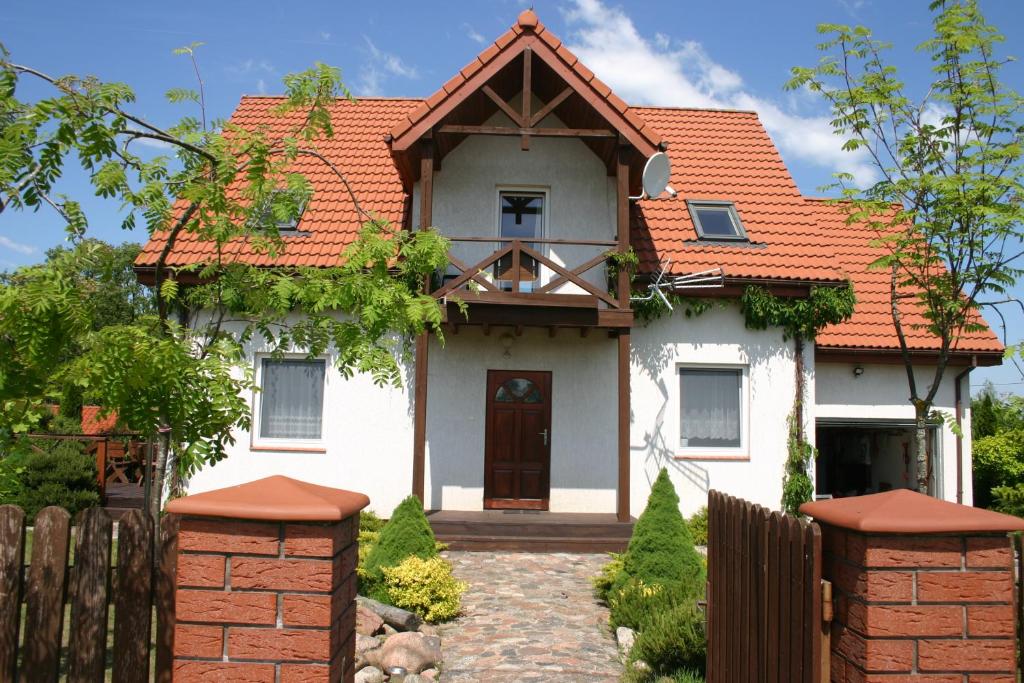 a white house with an orange roof at Willa Julianna in Mikołajki