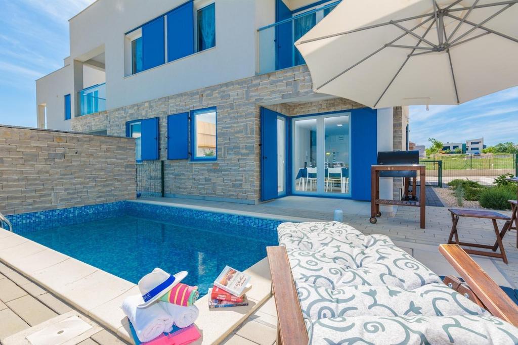 プリヴラカにあるVilla Miri Cherryのスイミングプールと傘付きのヴィラ