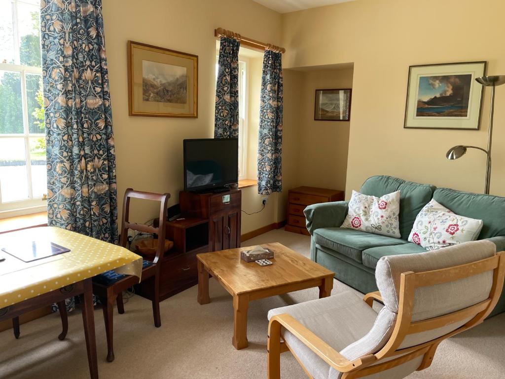 un salon avec un canapé et une télévision dans l'établissement Coachman's at Claremont Cottage, à St Andrews