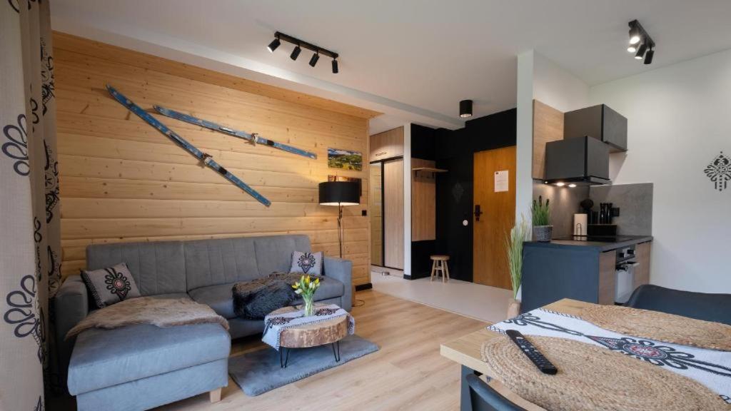 a living room with a couch and a table at Apartamenty Trzy Kopce SKI & BIKE & SAUNA in Ustroń