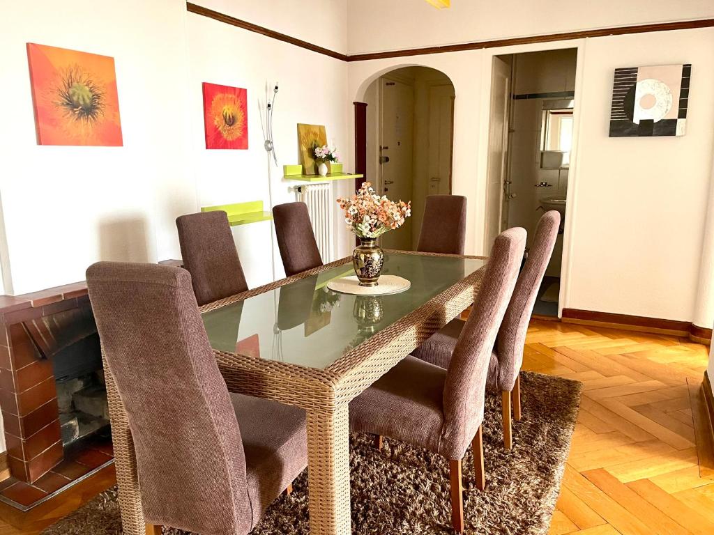 ein Esszimmer mit Glastisch und Stühlen in der Unterkunft Grand Appartement de 3 chambres in Lausanne