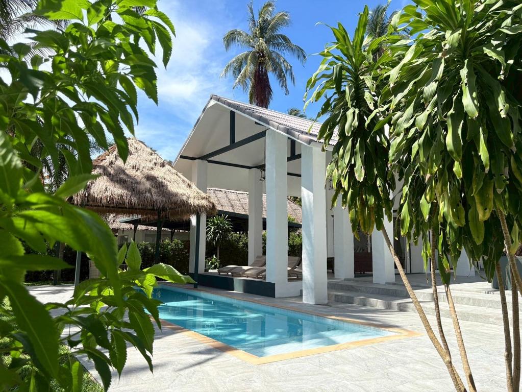 a villa with a swimming pool and palm trees at Tropical Garden Luxury Villa, Koh Phangan in Koh Phangan
