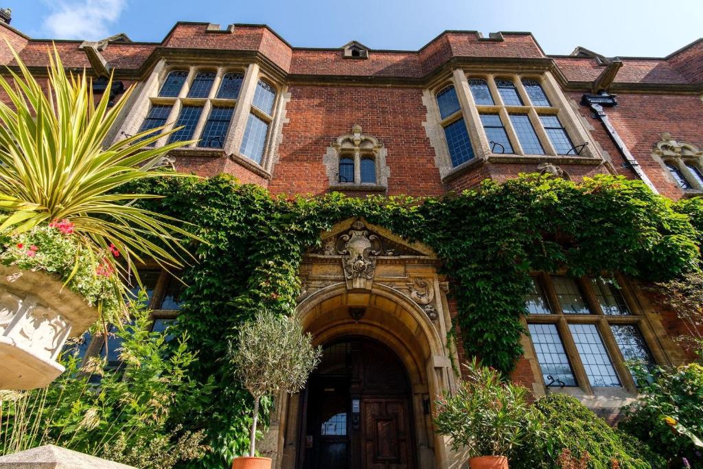 a large brick building with ivy growing on it at Westminster College Cottages, Cambridge in Cambridge