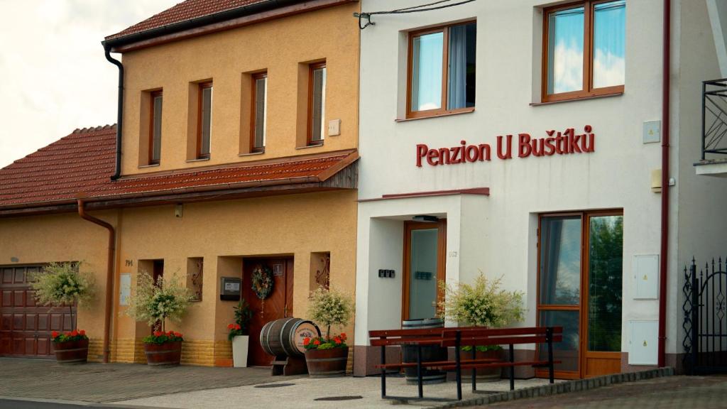 a building with two benches in front of it at Penzion U Buštíků in Šardice