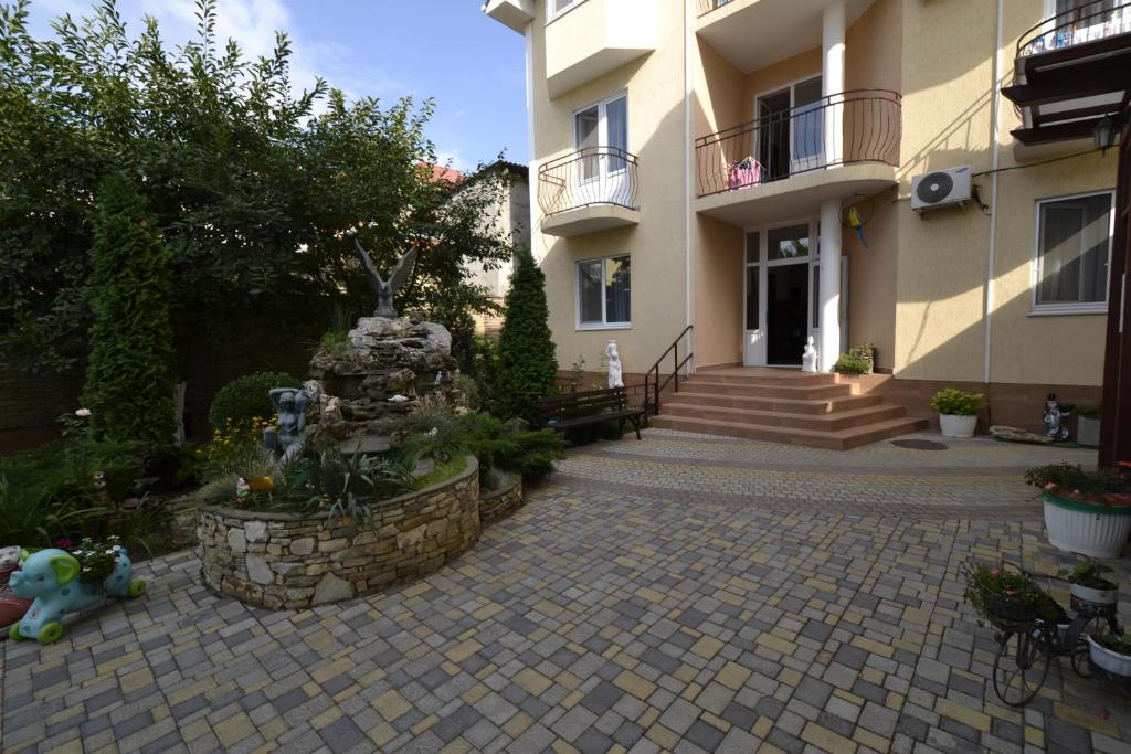 a courtyard with a fountain in front of a building at Vek Guest House in Anapa