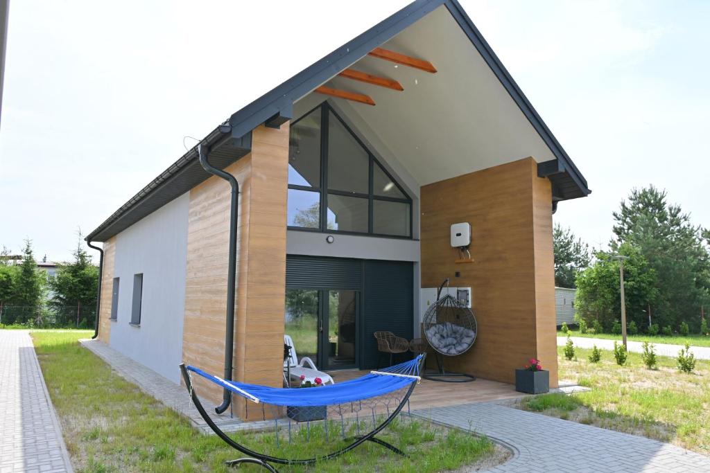 a house with a blue hammock in front of it at Ośrodek Szkoleniowo-Wypoczynkowy Akademii Bialskiej in Międzyrzec Podlaski