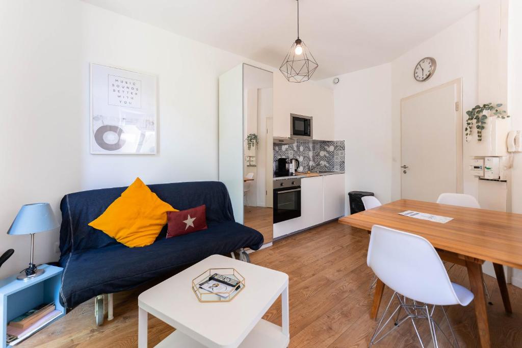 un salon avec un canapé bleu et une table dans l'établissement Colmar Historic Center - BELLE ALSACE - Studio 1 Terrasse - BookingAlsace, à Colmar