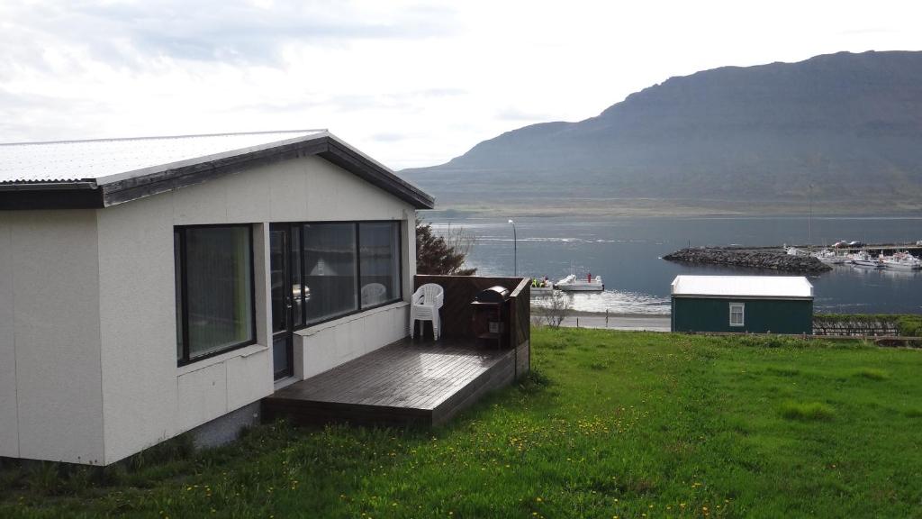 a house with a deck with a view of the water at Fjord Guesthouse in Súðavík
