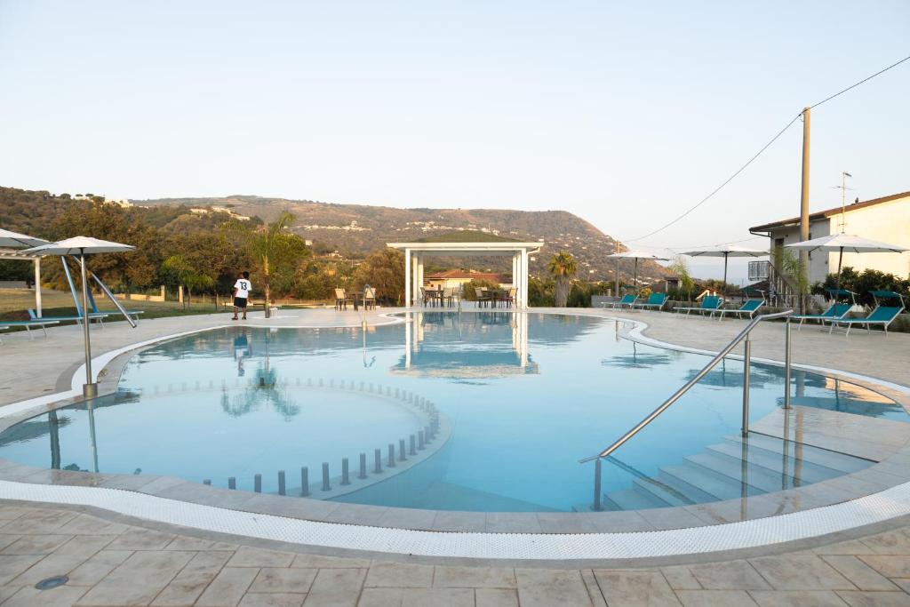 a large swimming pool with blue water at LA PERLA MARE- Wi-fi and free parking in Capo Vaticano