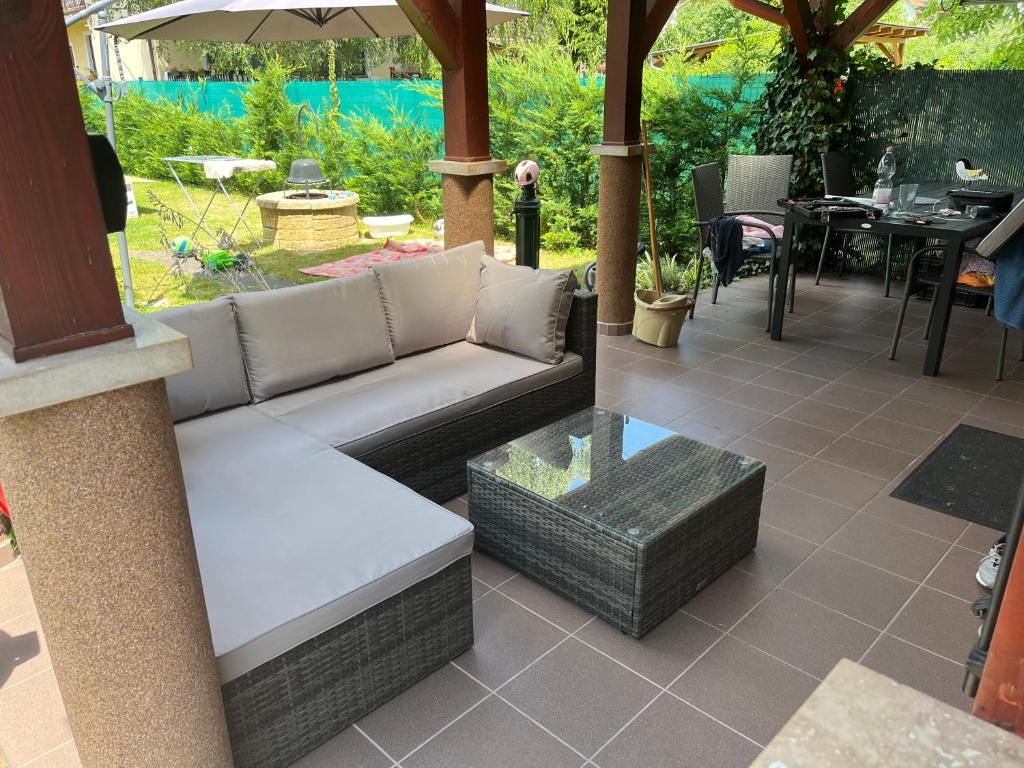 a patio with a couch and a table at Napocska Nyaralóház Keszthely in Keszthely
