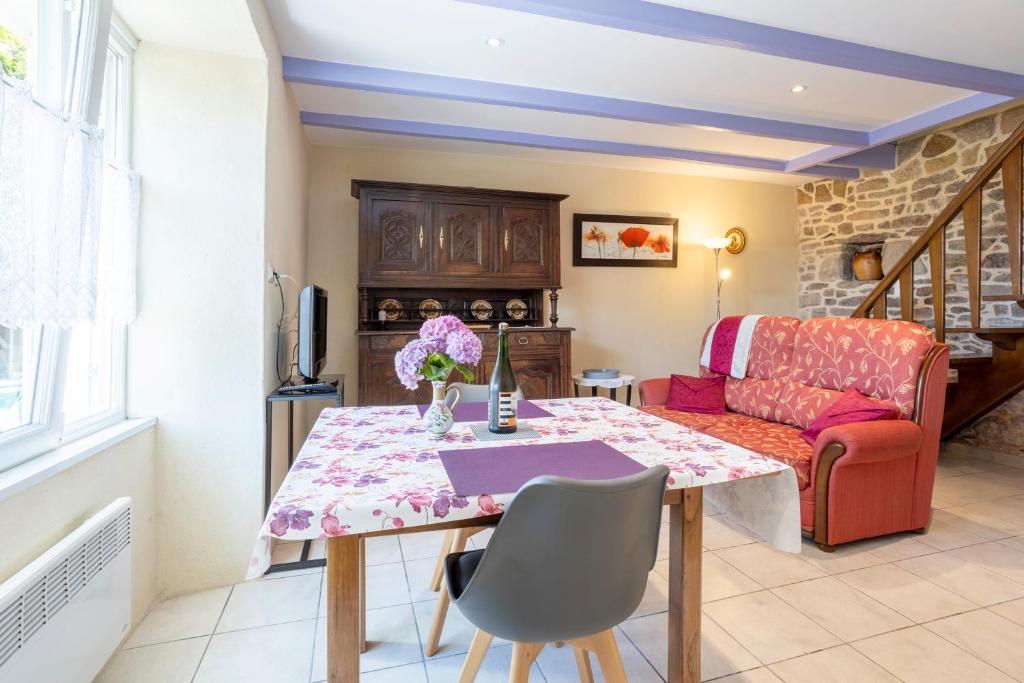 ein Wohnzimmer mit Tisch und Couch in der Unterkunft Gite Glycine, Kerantum in Mahalon