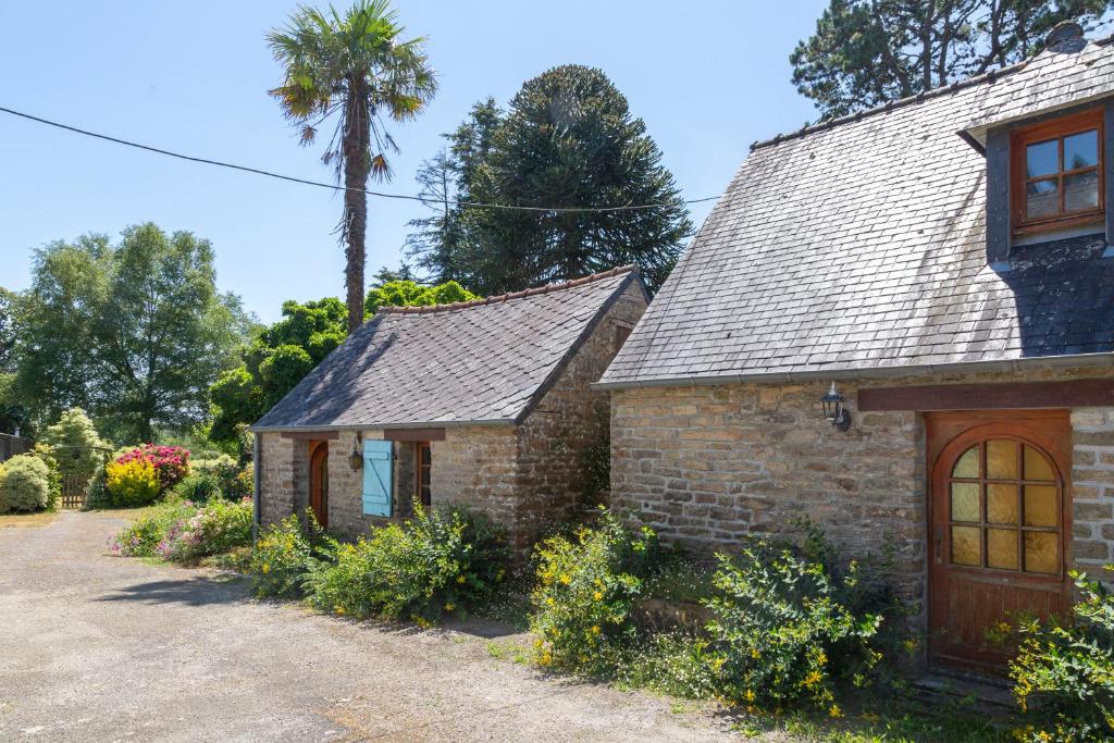 a brick house with a palm tree in the background at Gîte Ty Bihan in Rosporden