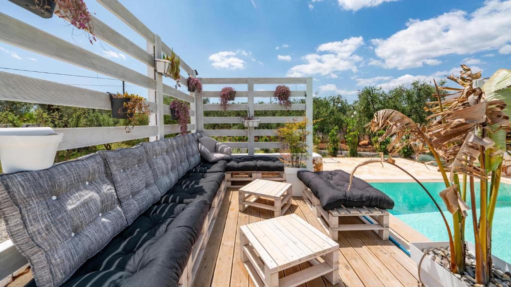 une terrasse avec un canapé et une piscine dans l'établissement Villa Frarogi by Rentbeat, à Ostuni