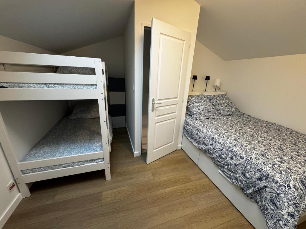 a bedroom with two bunk beds and a door at Maison pilotis 6 pers 50m mer in Les Moutiers