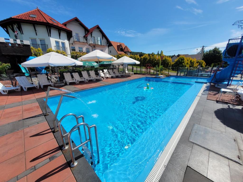 a pool at a hotel with a person swimming at Bartpol Family & SPA in Gródek Nad Dunajcem