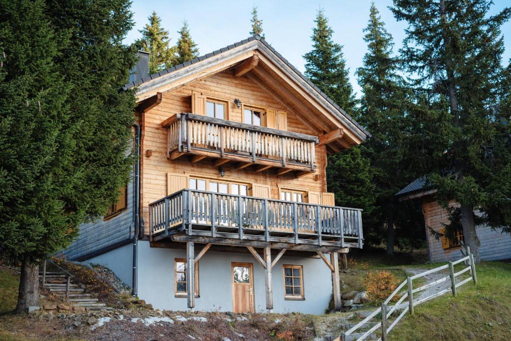 a large wooden house with a balcony on it at Feriendorf Koralpe Chalet Alpenperle in Hartelsberg