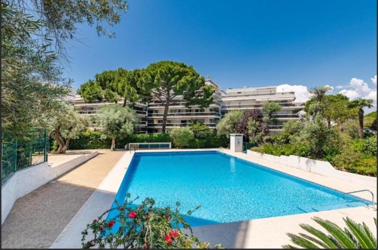 a large blue swimming pool in front of a building at Le lys d'or Piscine Plage Terrasse Wiffi in Juan-les-Pins