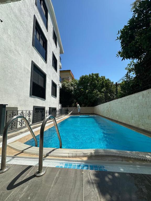 a large blue swimming pool next to a building at Sweet Apartment in Side