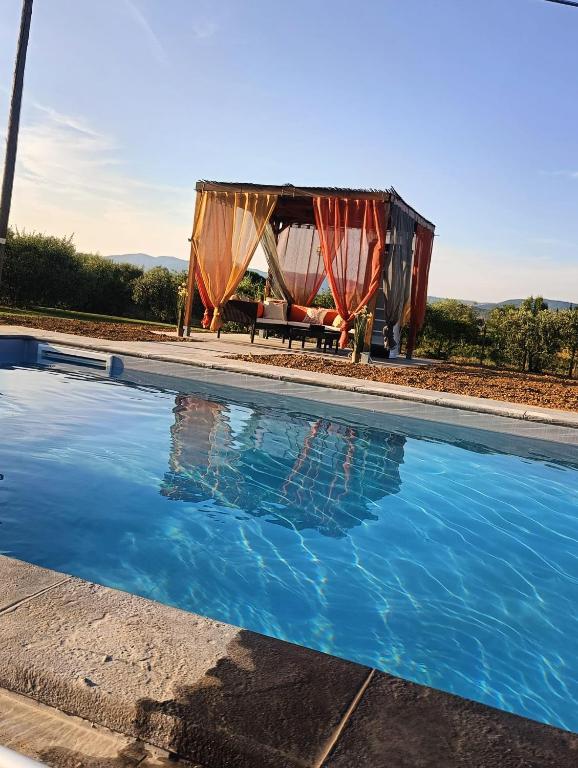 a house with a pool and a tent at CORTONA Piscina e Paradiso Verde Adults Only in Cortona