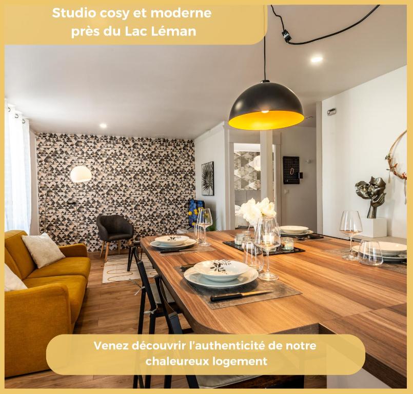 a dining room and living room with a table and a couch at Le Houx I T2 I Thonon-les-Bains in Thonon-les-Bains