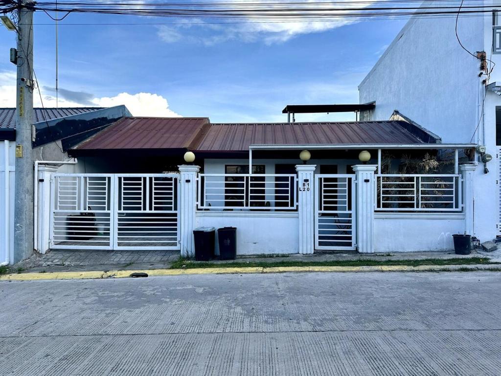 a white building with a red roof on a street at Scarlett Rae Bungalow house with Lake View in Angeles