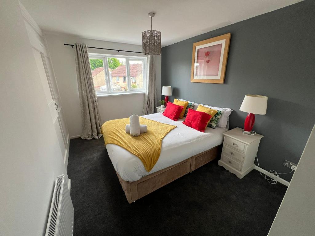 a bedroom with a large bed with red pillows at Cardiff Gate Lodge in Cardiff