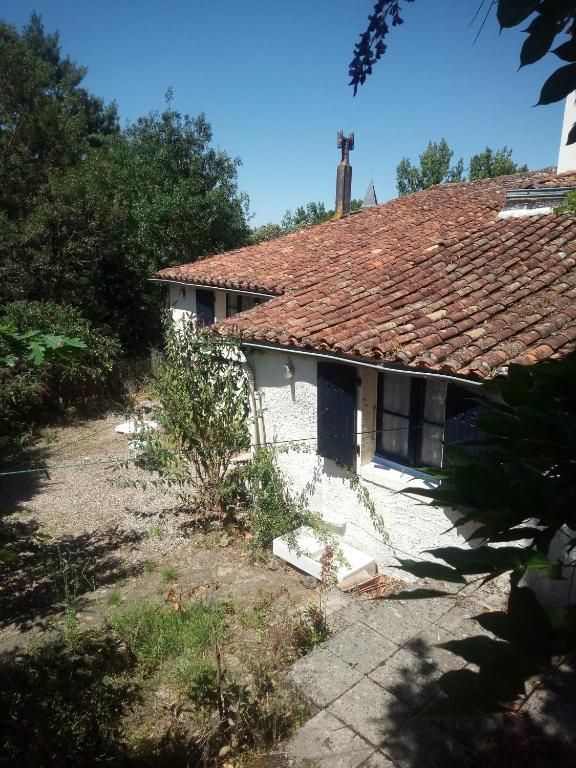 an old white house with a red roof at Gite Du Rocher in Mareuil-sur-Lay