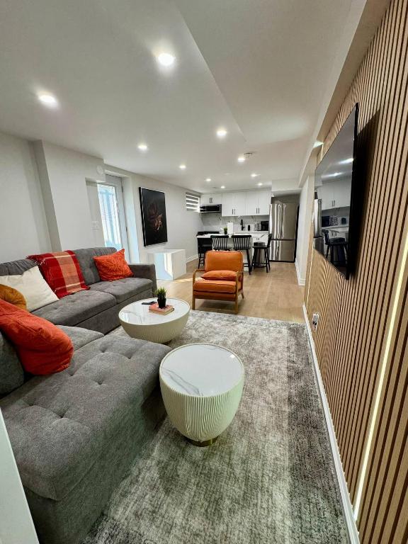 een woonkamer met een bank en een tafel bij 2 BR Private Basement Suite | Minutes from YYZ in Brampton