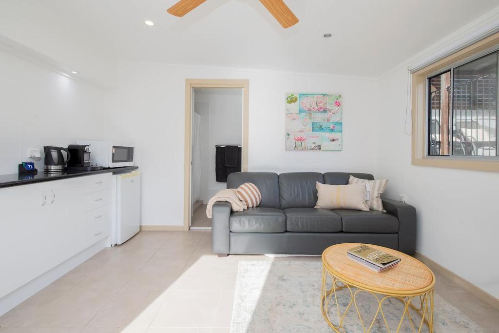 un soggiorno con un divano e un tavolo di Lake House Studio - A Peaceful Waterfront Hideaway a Karraganbah