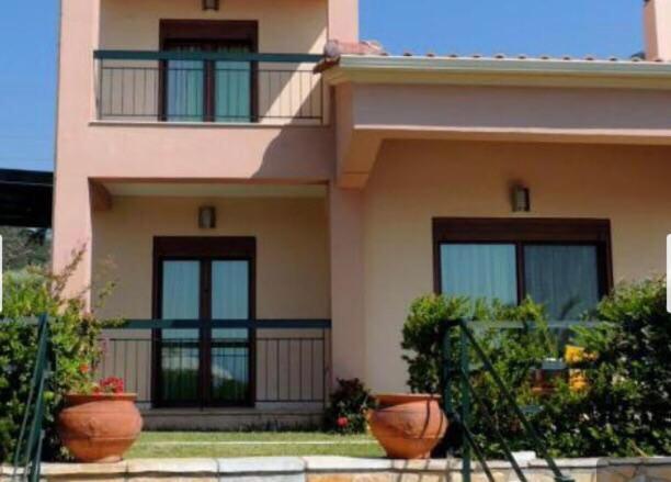 a house with two balconies and two plants in front of it at Green and Blue in Marathiás