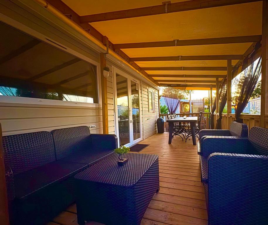une terrasse couverte avec des chaises et des tables bleues sur une maison dans l'établissement Au Ferret plage,piscines à 2 pas en famille by Vayny, à Lège-Cap-Ferret