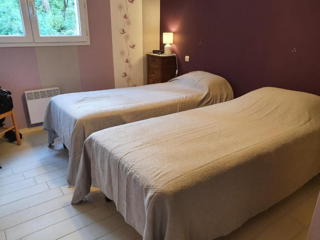 une chambre avec deux lits, une table et une fenêtre dans l'établissement CARCANS MAUBUISSON LOCATION SAISONNIERE VILLA 6 couchages, à Carcans