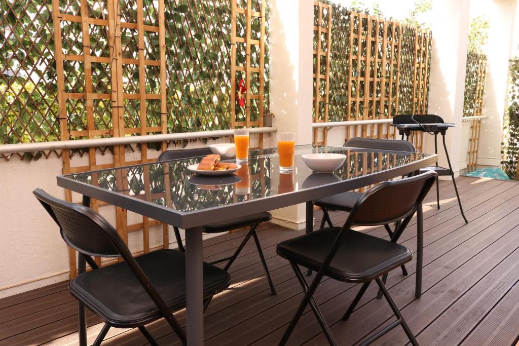 une table en verre et des chaises sur une terrasse avec des boissons dans l'établissement Terraza by Pom, au Cap d'Agde