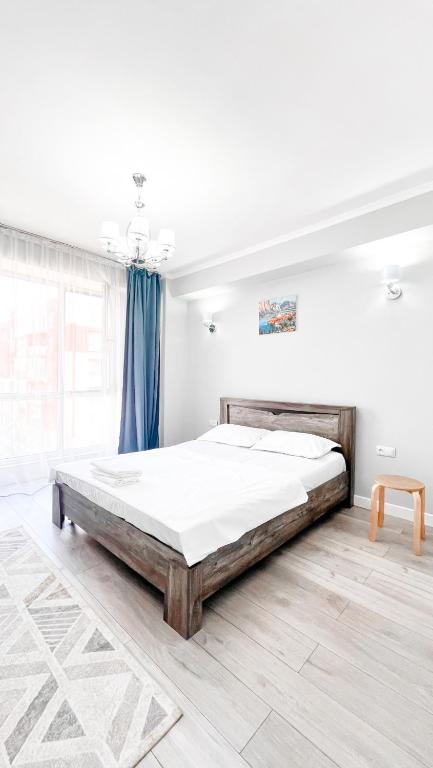 a bedroom with a large bed in a white room at Cozy Almaty Escape in Almaty