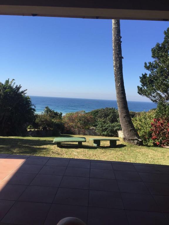 a picnic table in a park with a view of the ocean at Mac Cottage in Park Rynie