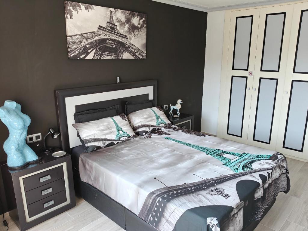 a bedroom with a bed and a picture of the eiffel tower at 100 Steps to the Sand. in La Tejita
